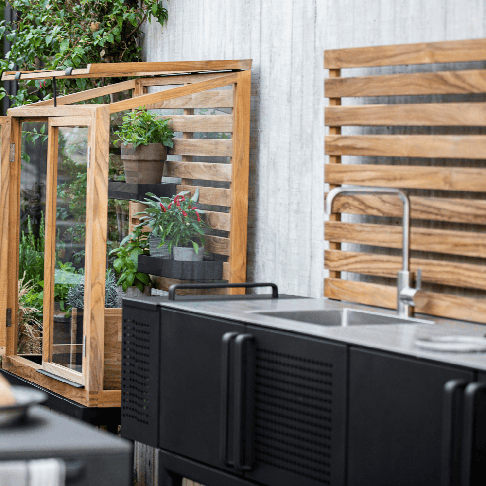 Boxhill's Drop Outdoor Kitchen Module with 3 Shelves lifestyle image beside Drop Teak Portable Green House at patio