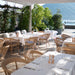 Natural rattan outdoor dining side chairs with matching dining tables on a restaurant terrace.