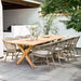 Grey rattan outdoor dining side chairs with a matching wooden dining table on a garden patio.