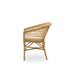 Natural rattan outdoor dining side chair in a light tan finish viewed from the side featuring an open woven back.