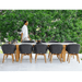 Boxhill's Endless Outdoor Rectangular Dining Table lifestyle image with 10 dining chairs at patio near the tree with a man walking at the side