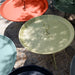 Modern outdoor accent side tables with round handles in various colors, placed on a concrete floor