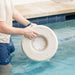 A person hands holding white in-pool side table in swimming pool.
