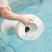 Hands submerging a modern white in-pool side table in swimming pool water.