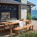 Natural wooden outdoor bench beside a matching picnic table set on a deck overlooking the water.