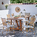 Natural wooden outdoor dining table with matching rattan dining chairs featuring striped woven backs and wicker seats.