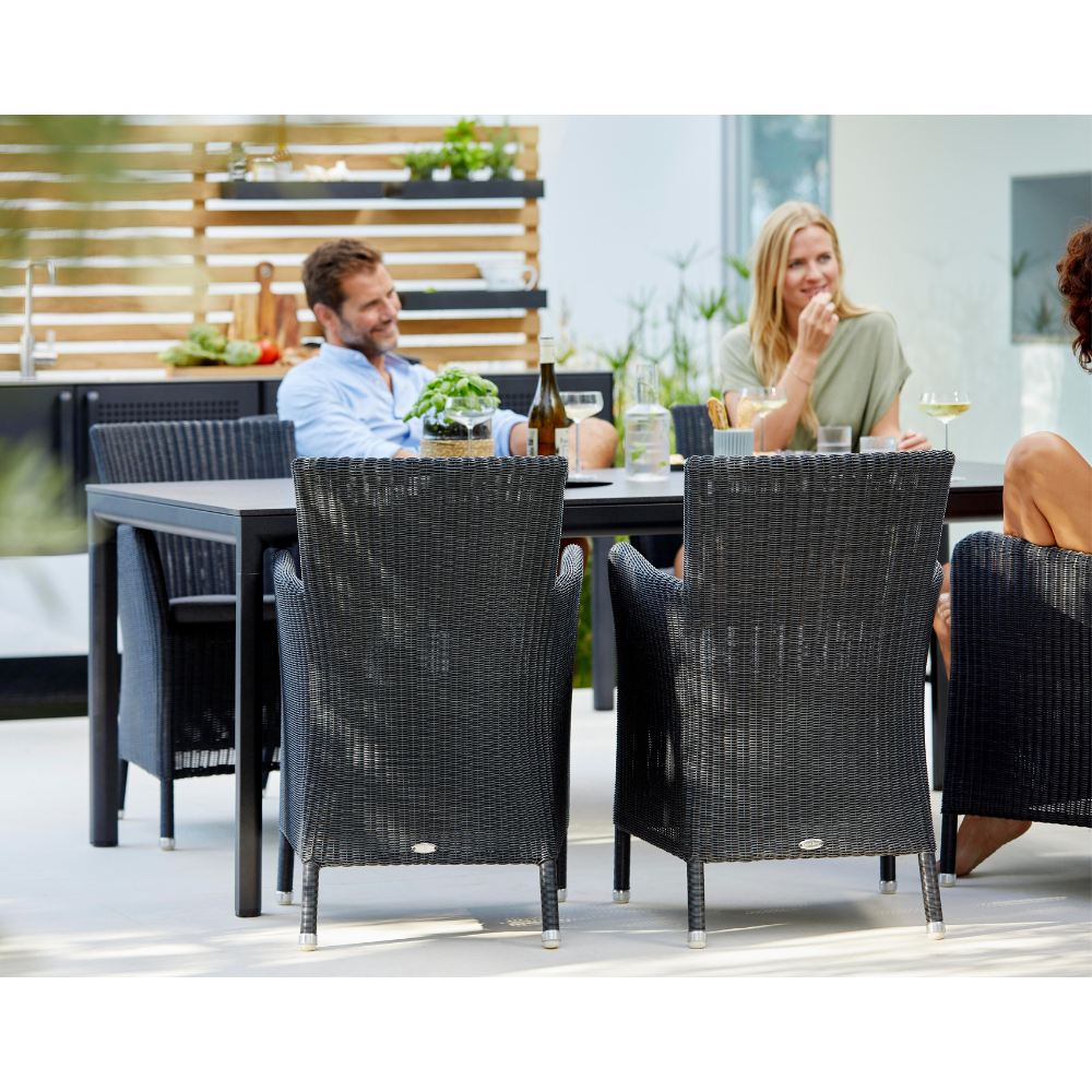 Boxhill's Hampsted Outdoor Dining Armchair lifestyle image with dining table and 3 people sitting down having a chat