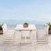 A white table with six chairs arranged on a patio, ideal for enjoying meals or gatherings outdoors.
