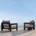Two outdoor lounge chairs on a patio with a scenic view in the background.