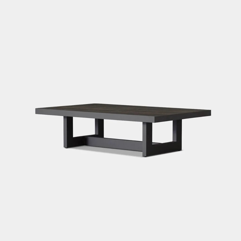 A modern aluminum frame coffee table with a black ceramic table top surface and a square base design.