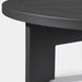 A black round aluminum coffee table with a sleek top and sturdy black base, close up view.