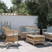 Natural wicker outdoor glass-top coffee table with matching seating featuring light blue cushions.