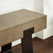 Close-view of a concrete outdoor bench with black metal legs on a wooden floor against white wall