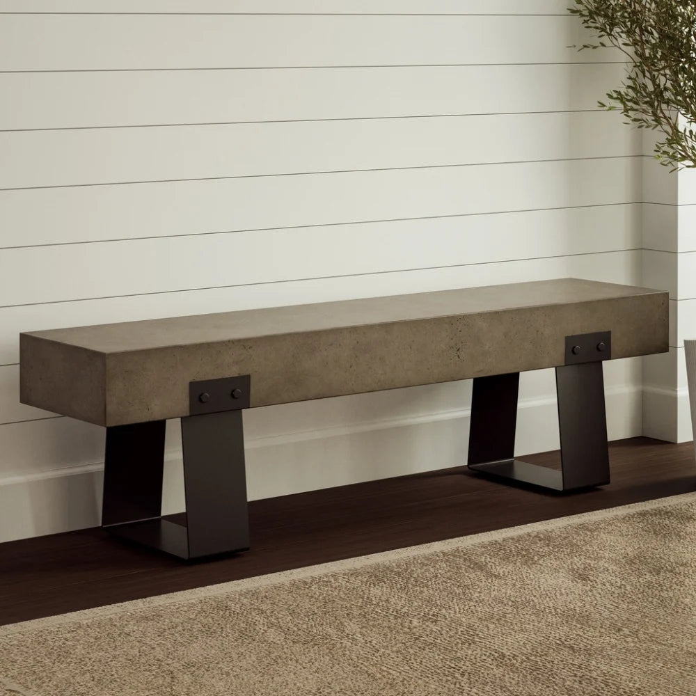 Gray outdoor concrete bench with black steel legs against wooden white wall in a minimalist interior with brown rug