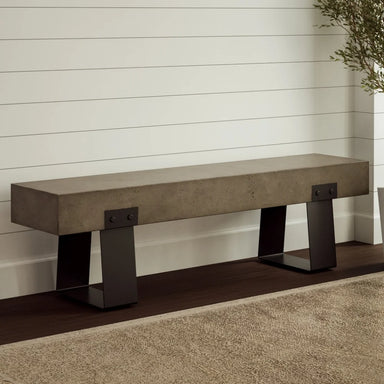 Gray outdoor concrete bench with black steel legs against wooden white wall in a minimalist interior with brown rug