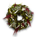 Handmade decorative wreath featuring green magnolia leaves, white leaves, red accents, and delicate dried flowers