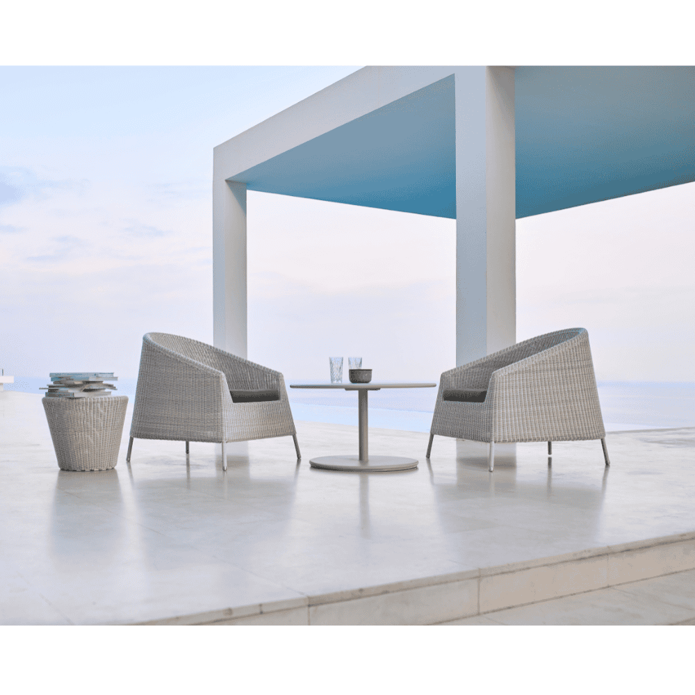 Boxhill's Kingston Outdoor Stackable Lounge Chair lifestyle image with Kingston Outdoor Footstool | Side Table and white round table beside the stairs