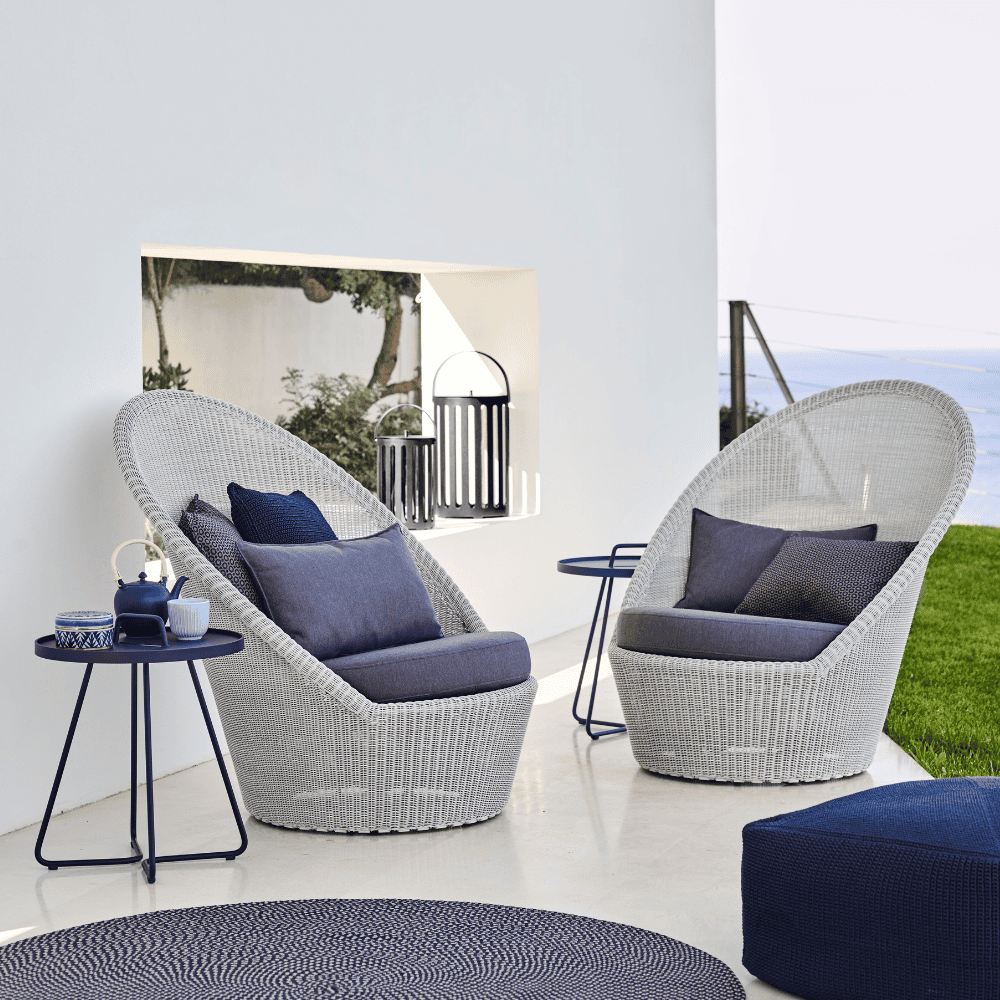 Boxhill's  Kingston Sunchair Lounge with Wheels lifestyle image with cushion, pillows, round side table and fabric footstool at patio