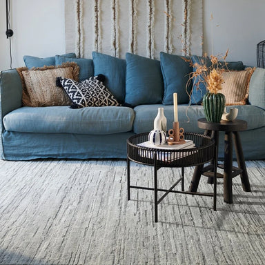 Rectangular rug in silver hand-tufted polyester with semi-plain textured pattern, living room setting