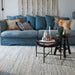 Rectangular rug in silver hand-tufted polyester with semi-plain textured pattern, living room setting