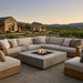 Outdoor patio with sectional sofa and square conrecrete grey fire pit table in a scenic setting