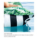 An inflatable pool float with a dual-sided design, featuring a green tropical leaf pattern on one side and bold black and white stripes on the other, shown floating on blue water with a person's arm resting on it.