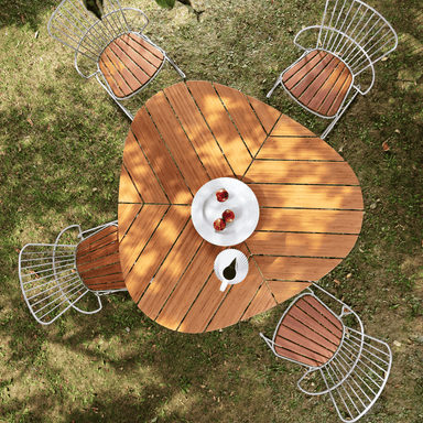 Top view of Leaf-shaped wooden outdoor dining table and 4 outdoor dining chairs with wooden seats set on a lawn surface