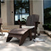 Dark brown outdoor high density polyethylene resin Adirondack chair with matching footrest on a patio, styled with a white faux-fur cushion and a white cup on a tray.