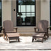 Two dark brown high density polyethylene resin Adirondack-style outdoor lounge chairs with matching ottomans on a patio in front of a modern house with large black-framed glass doors.
