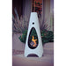  White cone-shaped outdoor metal fire pit with visible flame at the center, stands on a concrete patio beside green plants
