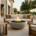 Outdoor patio with round concrete fire pit, seating area, and city skyline view