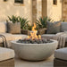 Outdoor patio with round concrete fire pit, couches, and plants