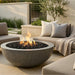 Outdoor patio with round concrete fire pit, seating area, and garden elements.
