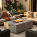 Outdoor patio with fire pit table, comfortable seating, and decorative elements.