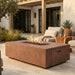 Outdoor patio with fire pit table, seating area, and potted plants.