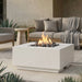 Outdoor patio with a square concrete white fire pit table and seating area