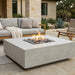 Outdoor patio with a white square concrete fire pit table and seating area.