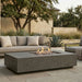 Outdoor patio with rectangular concrete fire pit table and seating area