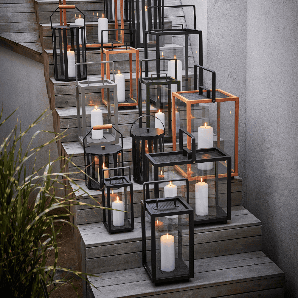 Boxhill's Lighthouse Outdoor Large Aluminum Lantern for Candles | Set of 2 lifestyle image with different sizes, together with Lighthouse Outdoor Large Teak Lantern and  Lighttube Outdoor Large Lantern, on the stairs