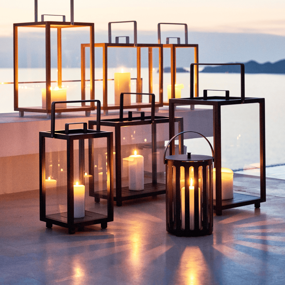 Boxhill's Lighttube Outdoor Large Lantern | Set of 2 lifestyle image with Lighthouse Outdoor Large Aluminum Lantern and Lighthouse Outdoor Large Teak Lantern at seafront
