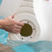 A person’s hand removing water from inside a white in-pool chaise in a swimming pool.