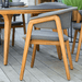 Boxhill's Luna Outdoor Dining Armchair Lifestyle image side view with teak round table at patio
