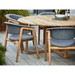 Boxhill's Luna Outdoor Dining Armchair Lifestyle image with teak round table at patio