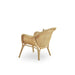 Natural rattan outdoor lounge chair viewed from the angled rear featuring a woven backrest and curved arms.