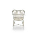 White rattan outdoor dining armchair viewed from the rear featuring an open slatted back and curved arms.