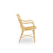 Natural rattan outdoor dining armchair viewed from the side with an open slatted back and woven seat.