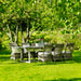 Gray rattan outdoor dining side chairs with white cushions and a matching rectangular dining table.