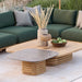 Patio seating with a green cushioned sectional sofa, a large wooden square outdoor coffee table, and a small coffee table with gray ceramic top.