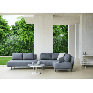 Boxhill's Moments 2-Seater Sofa Module lifestyle image at patio with Moments Outdoor Corner Module and round coffee table with a cup and pot on top