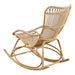 Natural rattan outdoor rocking chair viewed from the angled rear featuring an open slatted back and rocker rails.